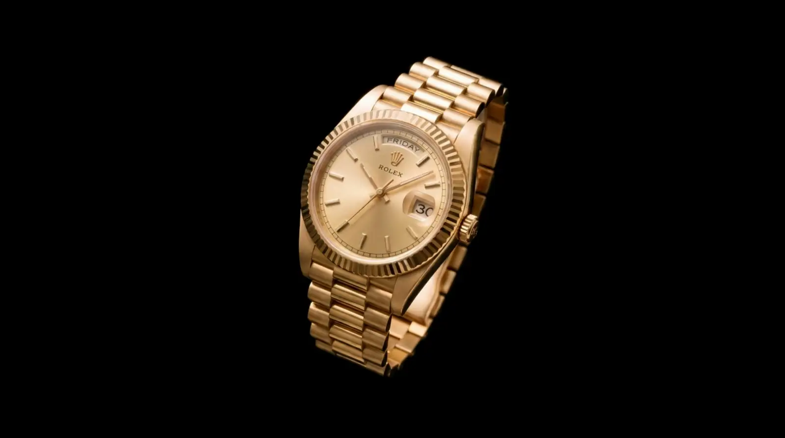 A gold wristwatch on a black background, turning slowly as light sweeps across it